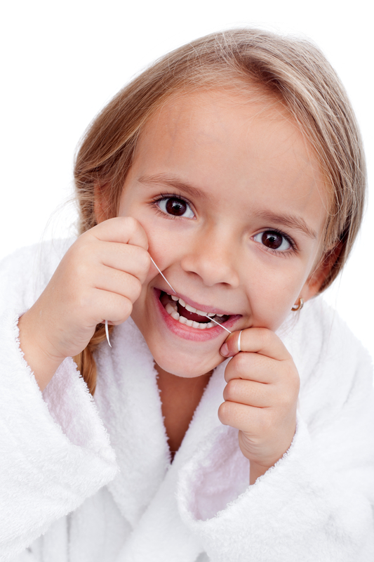 devojčica koristi zubni konac