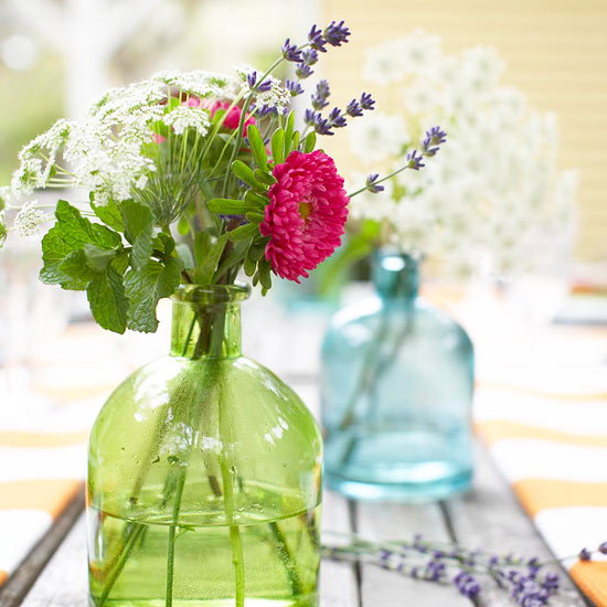 Ukoliko želiti rustični izgled vašeg stola u obojenu staklenu flašu stavite sveže ubrano poljsko cveće. Source: http://www.bhg.com/