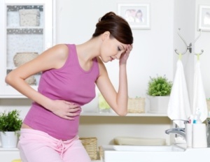 Pregnant woman with strong pain of stomach and nausea